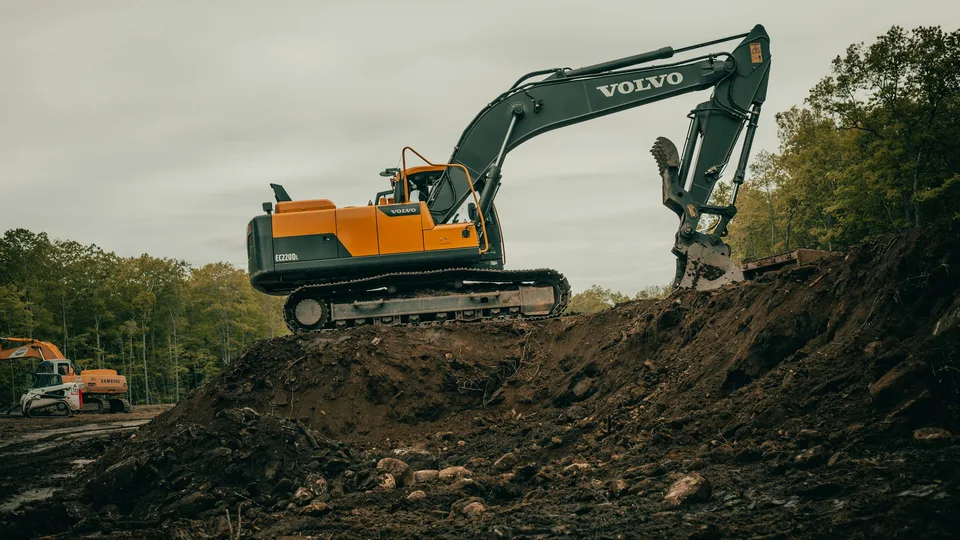 Excavator digging a trench for a septic system installation