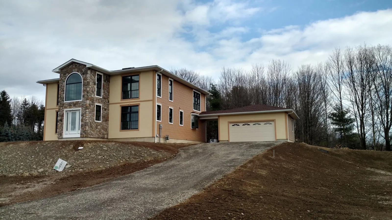 Completed Barden panelized home in Vestal, NY with stone chimney accent and attached two-car garage